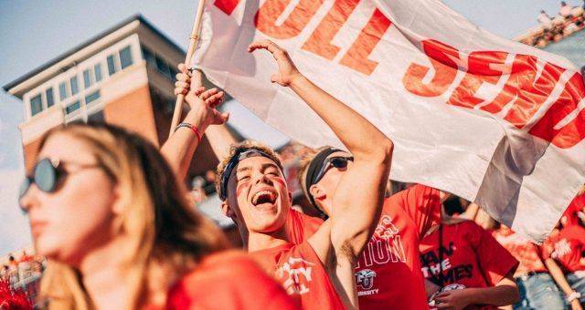 fans dressed in red holding banner