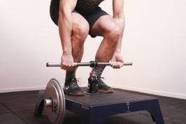 Man deadlifting with a mixed grip using a knurled kBar on a kBox4 Pro loaded with high inertia