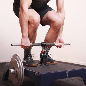 Man deadlifting with a mixed grip using a knurled kBar on a kBox4 Pro loaded with high inertia