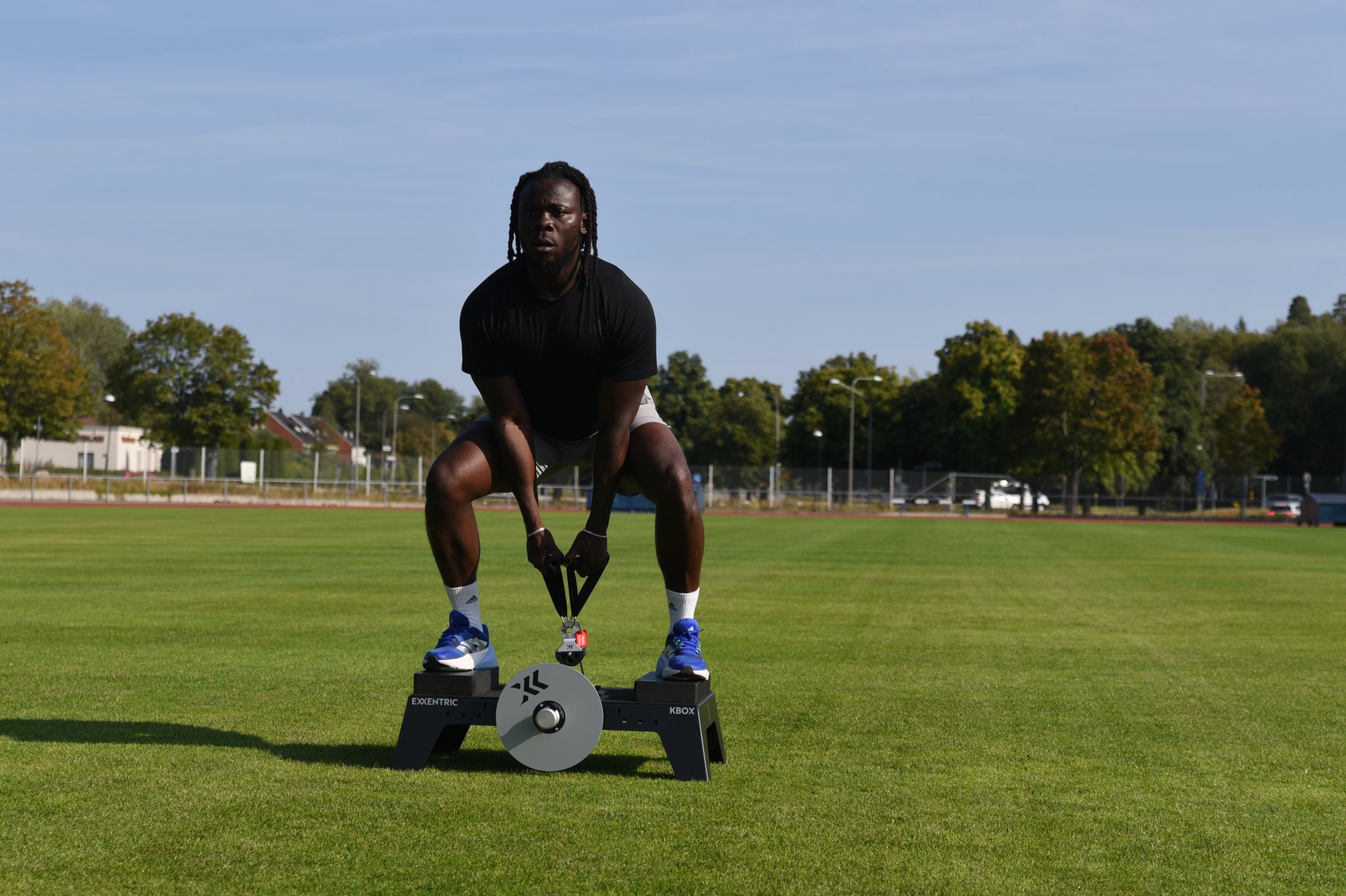 Man deadlifting on kBox in a field