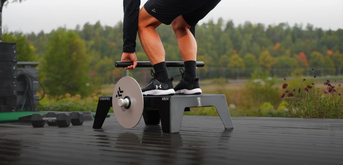 Man on kBox Active doing a deadlift in backyard